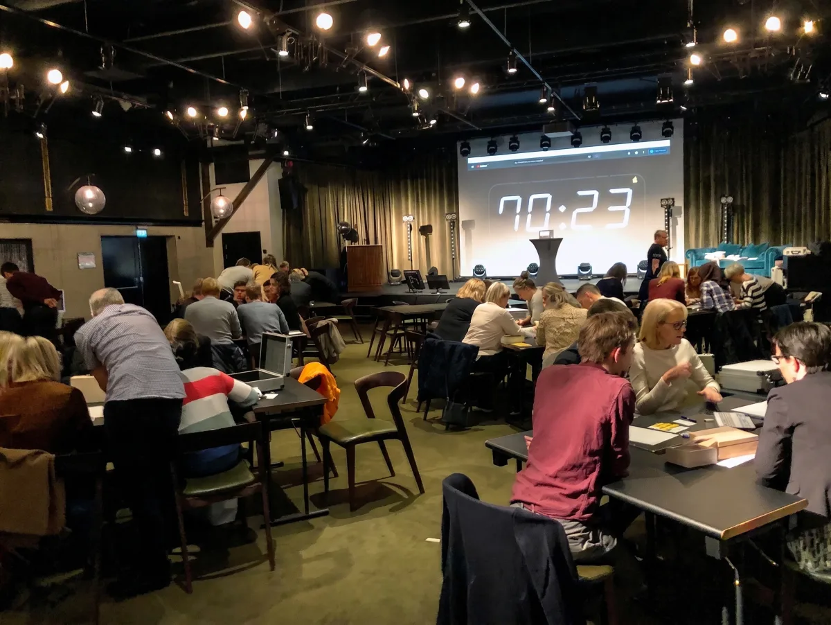 Digital nedräkningsklocka på storbild medan lagen jobbar mot tiden